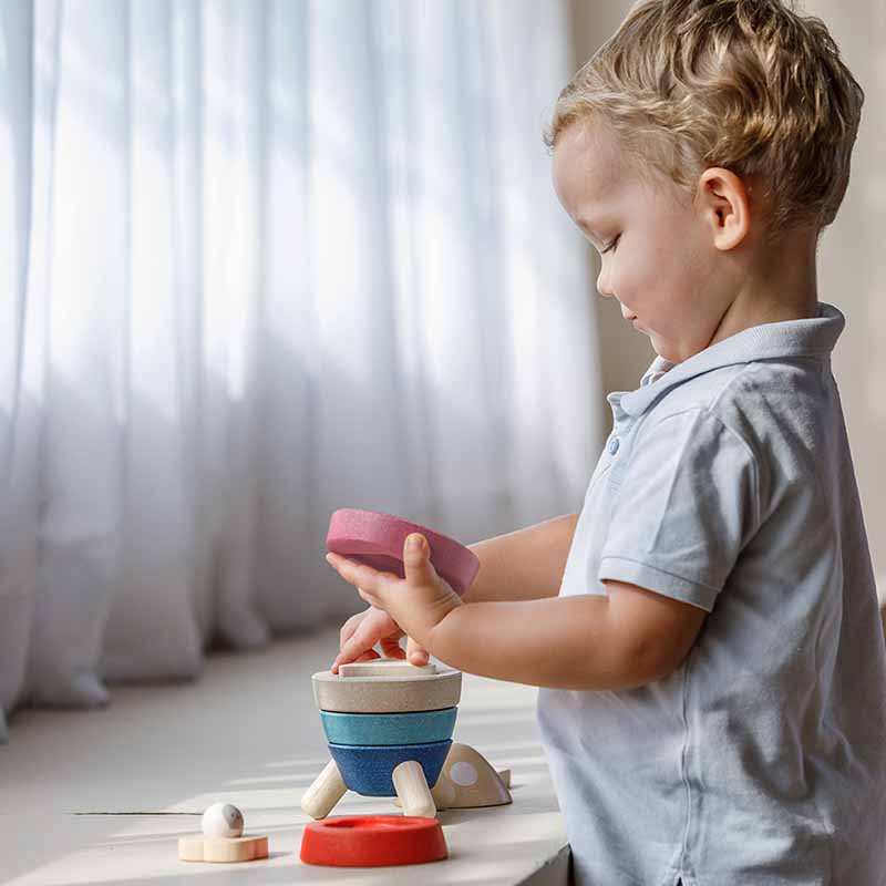 Wooden Stacking Rocket (Orchard Edition) boy by window