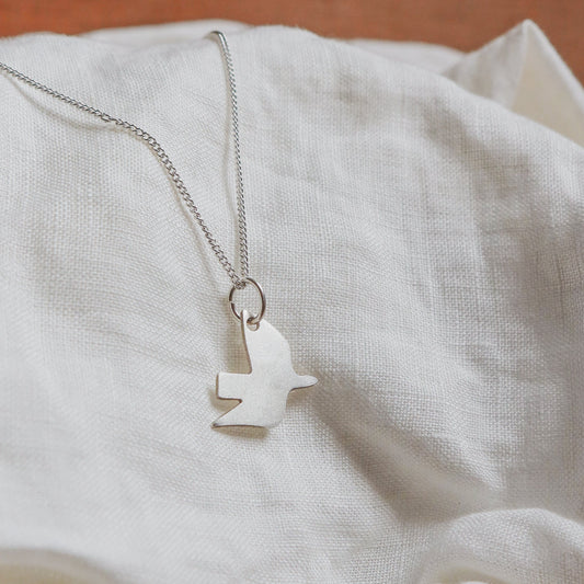 RECYCLED SILVER DOVE NECKLACE on cloth